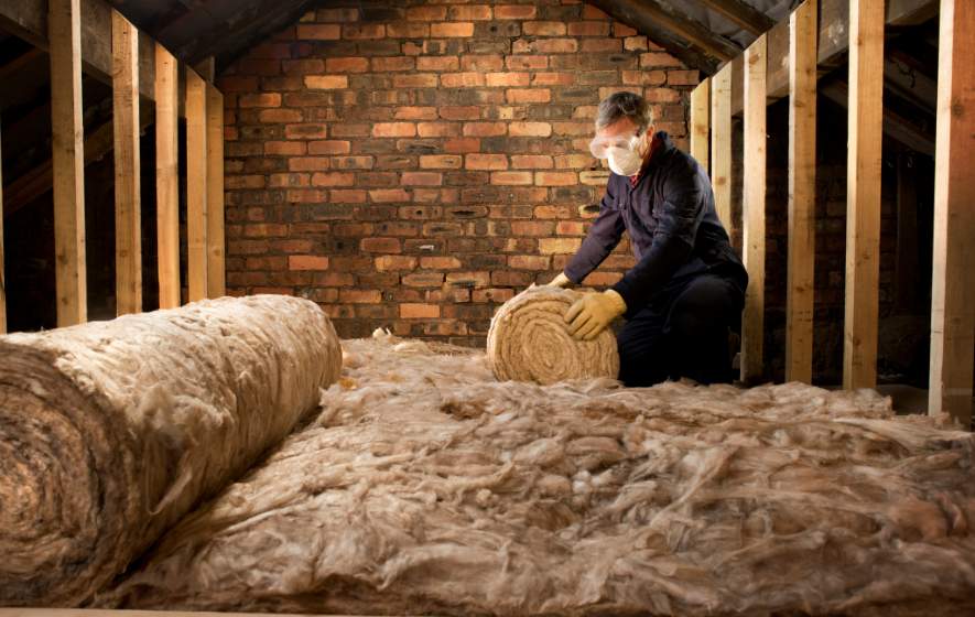 A cork attic with insulation being installed, showing layers of material and tools